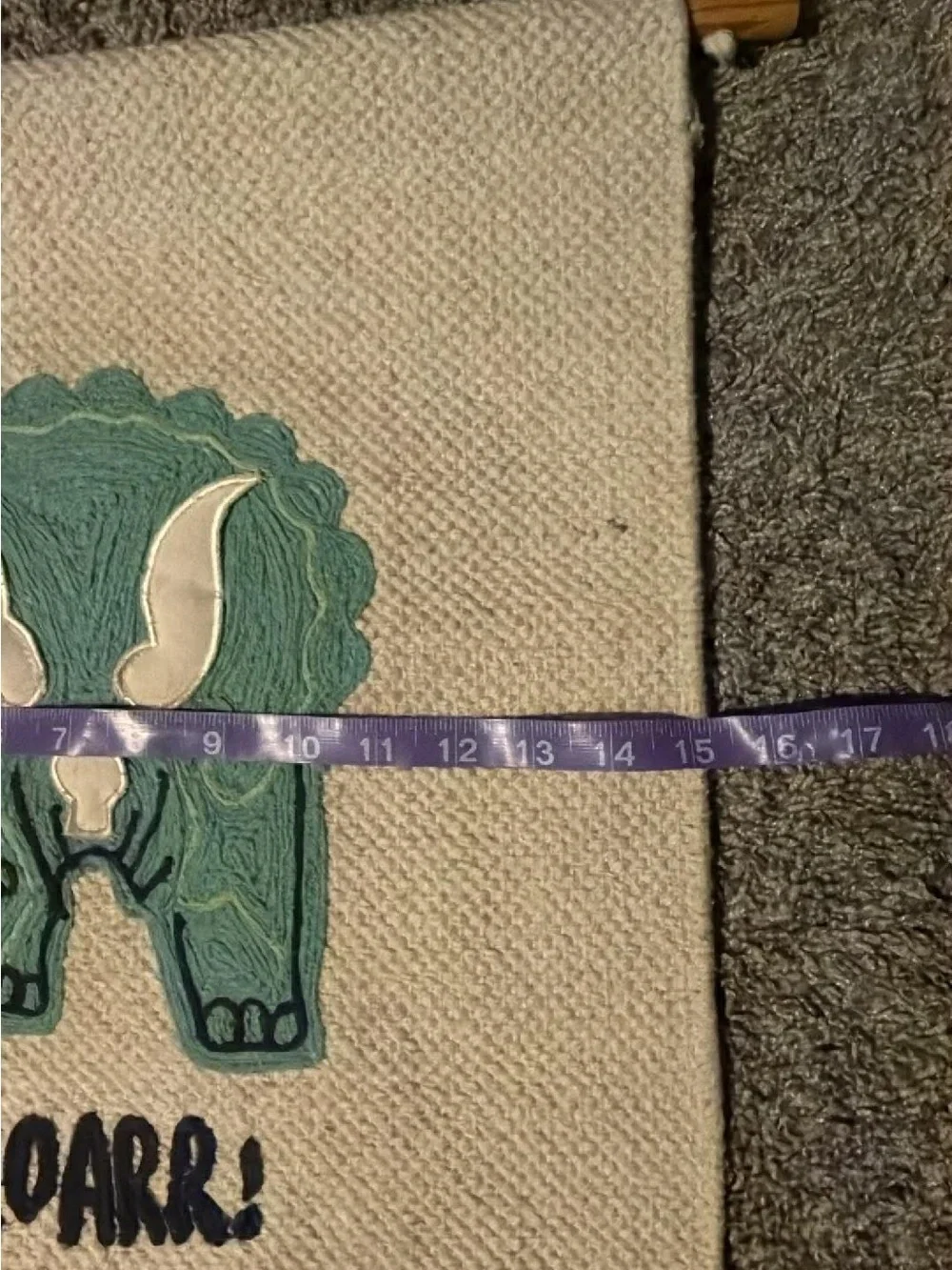 Handwoven Cream Wall Hanging with Green Triceratops Motif Nursery Design